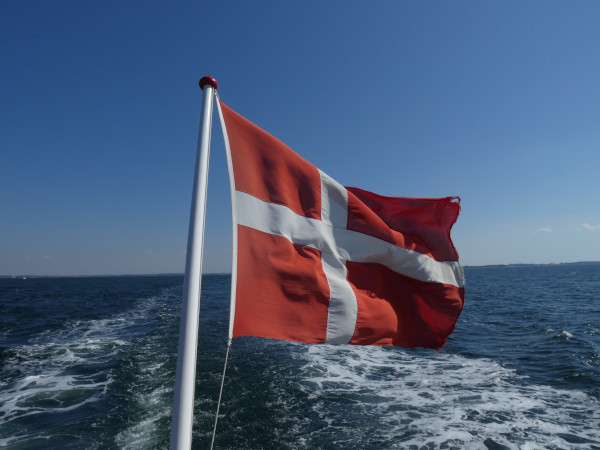 Dänische Flagge am Heck einer Fähre im Fahrtwind, Blick Richtung offenes Meer